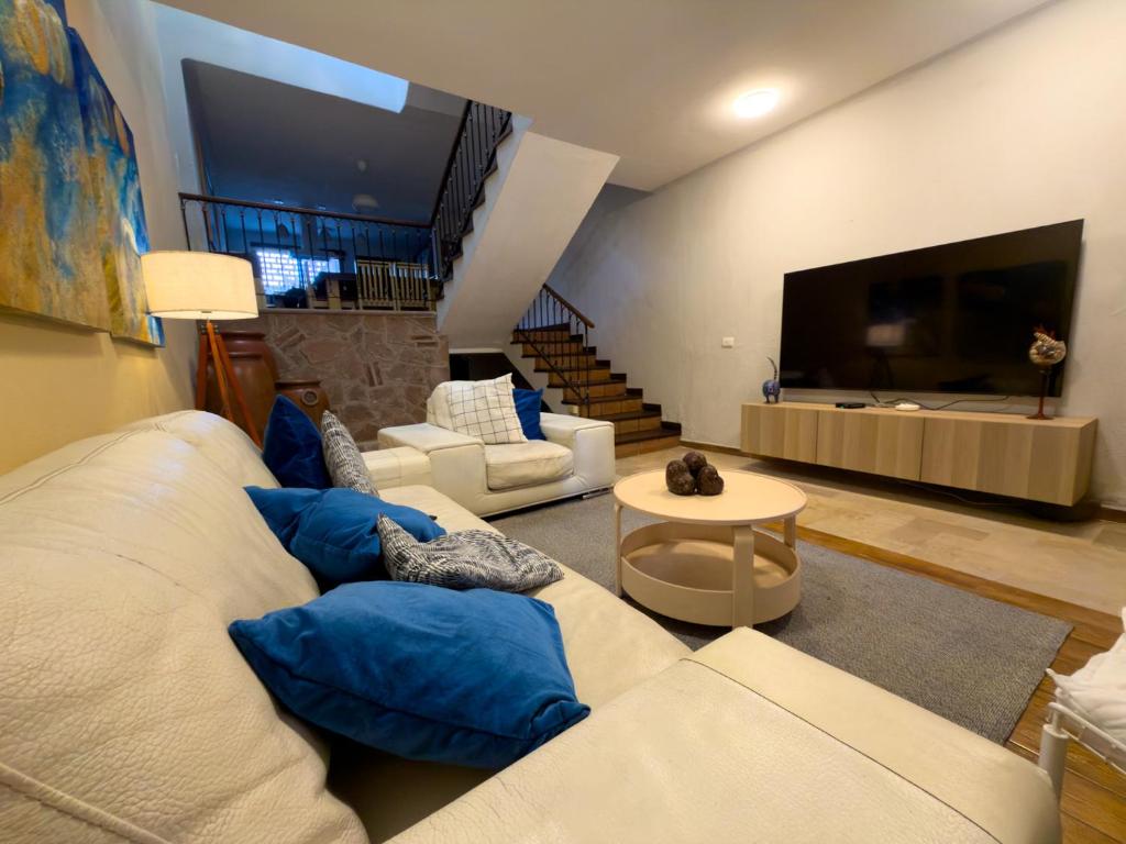a living room with a white couch and blue pillows at Casa Céntrica con Roof garden y Vistas a la Ciudad in Guadalajara