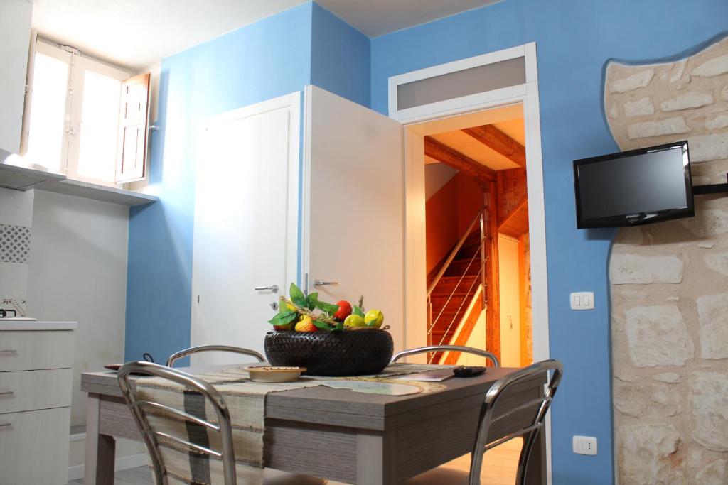 uma sala de jantar com paredes azuis e uma mesa com cadeiras em A Casa di Turiddu em Scicli