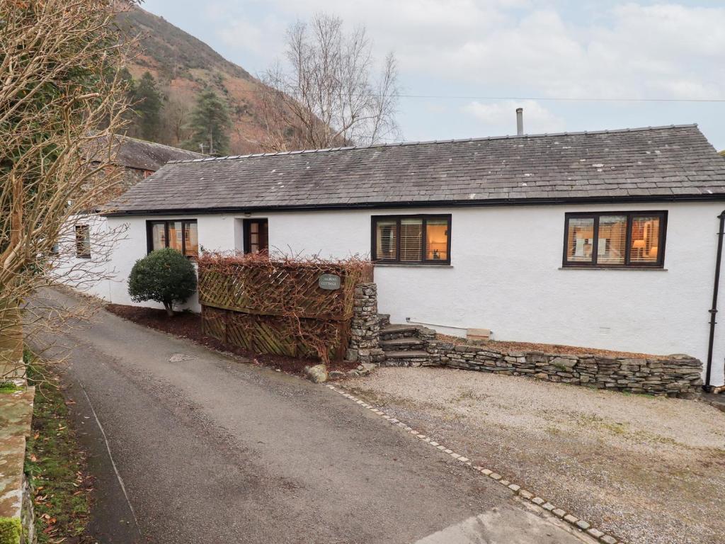 a white house with a road in front of it at Jasmine Cottage in Keswick