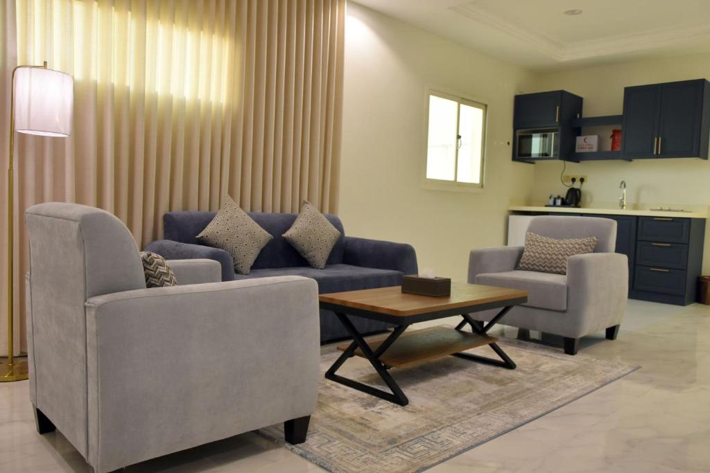 a living room with a couch and two chairs and a table at غيمة in Hail