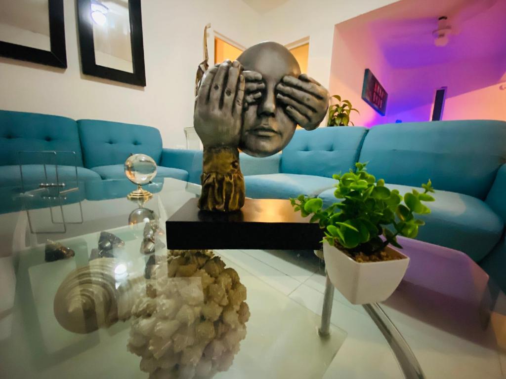 a living room with a statue of a person with their hands on a table at Departamento 2 Habitaciones Cas Consulado Centenario in Hermosillo
