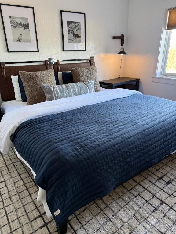 a large bed with a blue comforter in a bedroom at High Pines Haven in Angel Fire