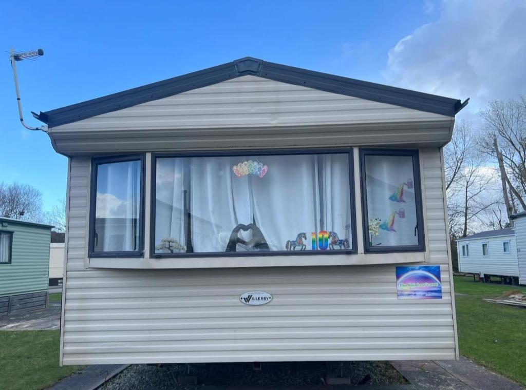 a house with a dog sitting in a window at The Rainbow's nest in Morecambe