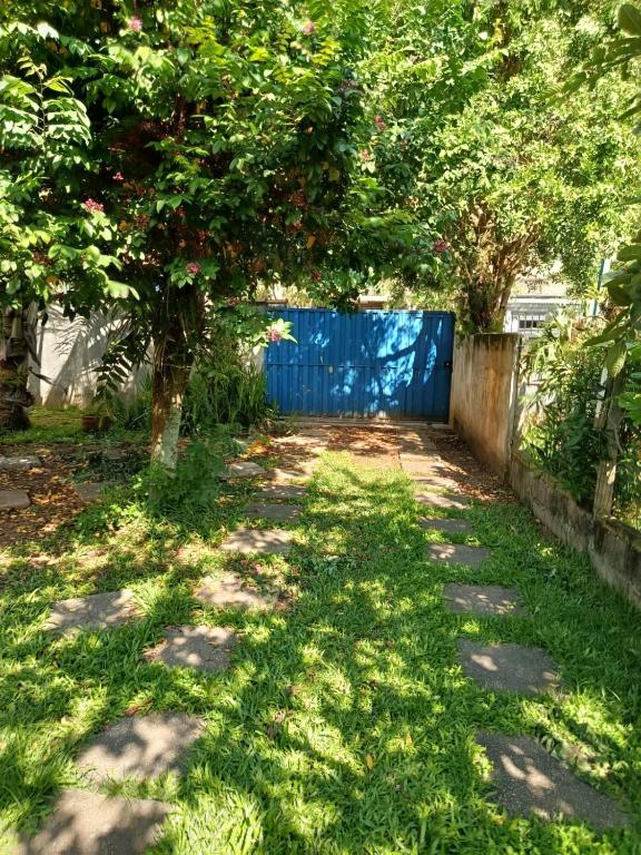 a garden with a blue fence and a tree at Refúgio Sereno São Seba in São Sebastião