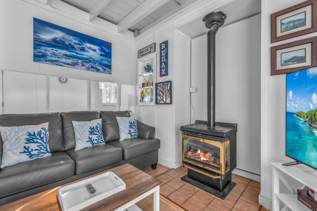 a living room with a couch and a fireplace at Coral Cottage in Depoe Bay