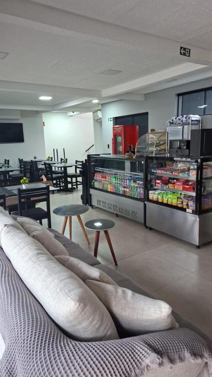 a room with a couch and some tables and chairs at Hotel Pousadas Club Centro in Sorocaba