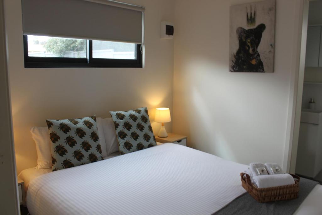 a bedroom with a white bed and a window at Lunar Cabins in Parkes