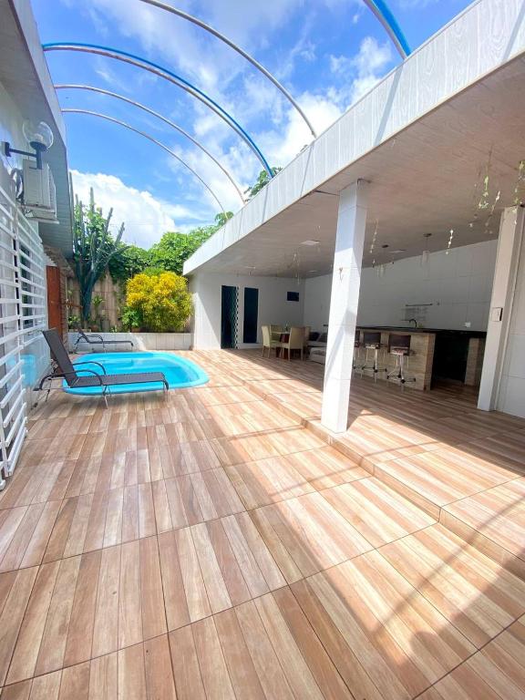 an indoor patio with a wooden floor and an indoor swimming pool at Casa compartilhada com Quarto e Suite no Parque 10 in Manaus