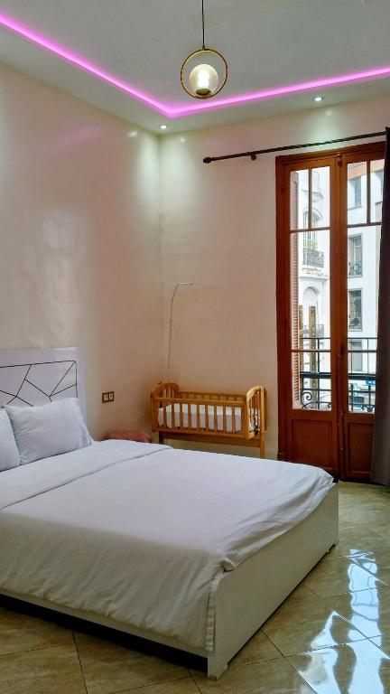 a bedroom with a large bed with a pink lighting at Neoclassical apartment downtown in Casablanca