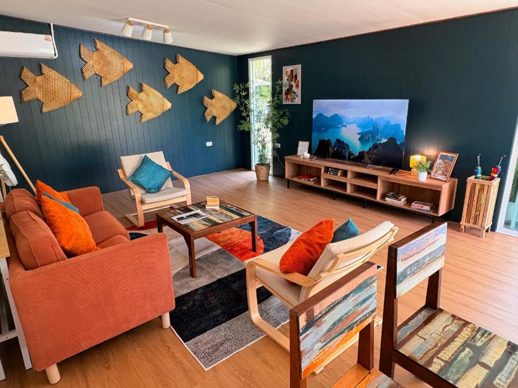 a living room with a couch and a tv at Bamboo Beach House @ Phang Nga in Thai Muang