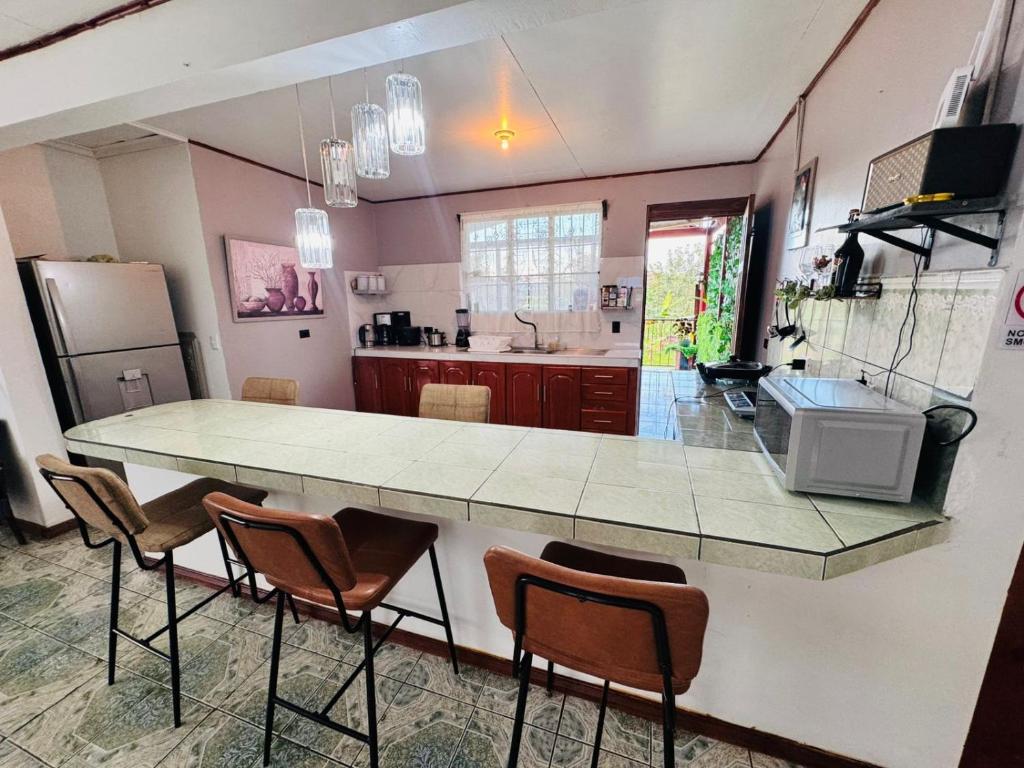 a kitchen with a large counter with chairs in it at Casa de Campo Arenal in San Francisco