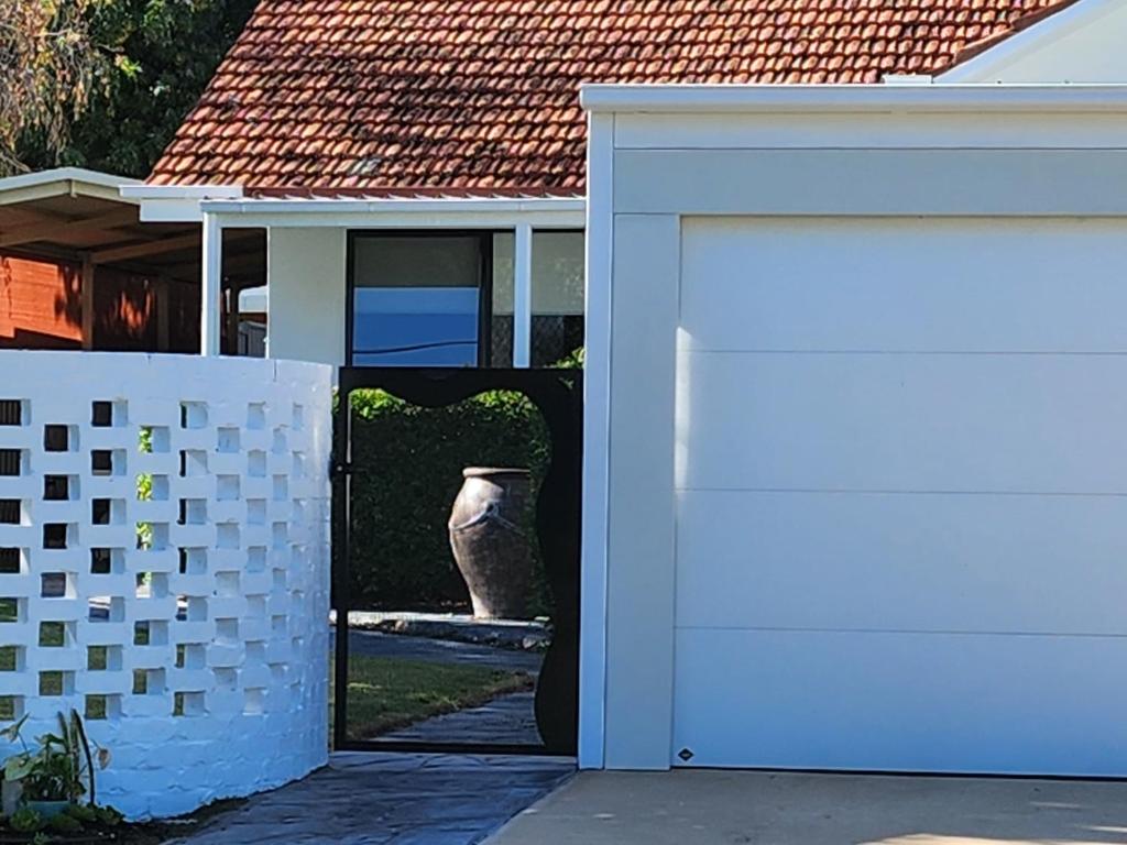 a white garage door in front of a house at House on Heron in Mildura