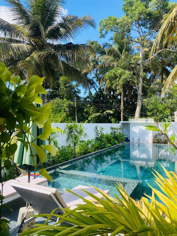a swimming pool in a villa with palm trees at Villa 2A in Matara