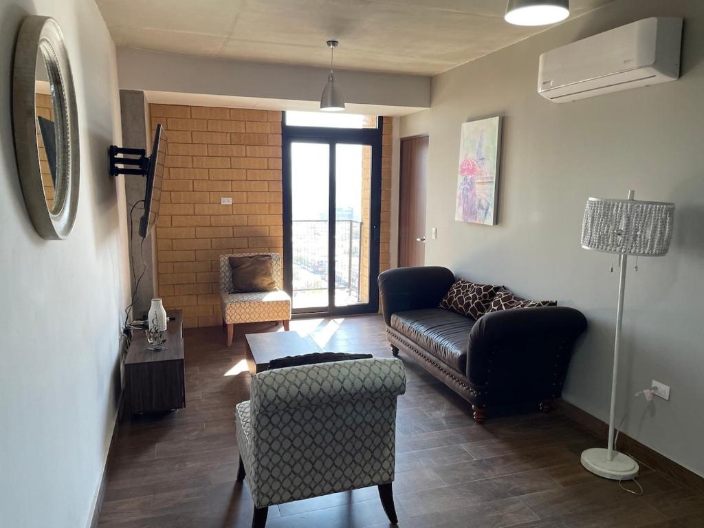 a living room with a couch and a chair at Departamento en Torre Historicah in Monterrey