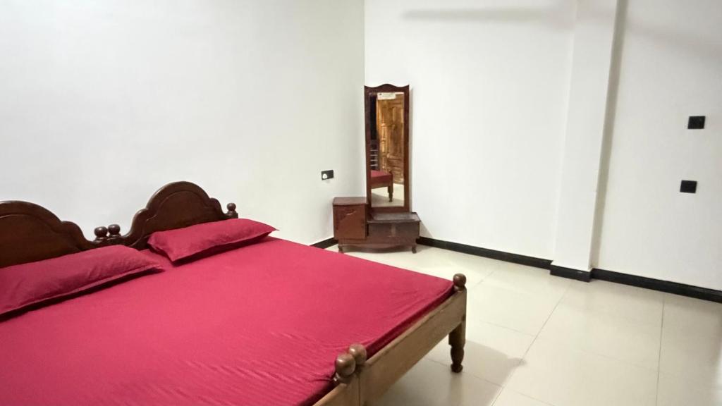 a bedroom with a bed with a red blanket at Nikshi Guest House in Nikawatawana