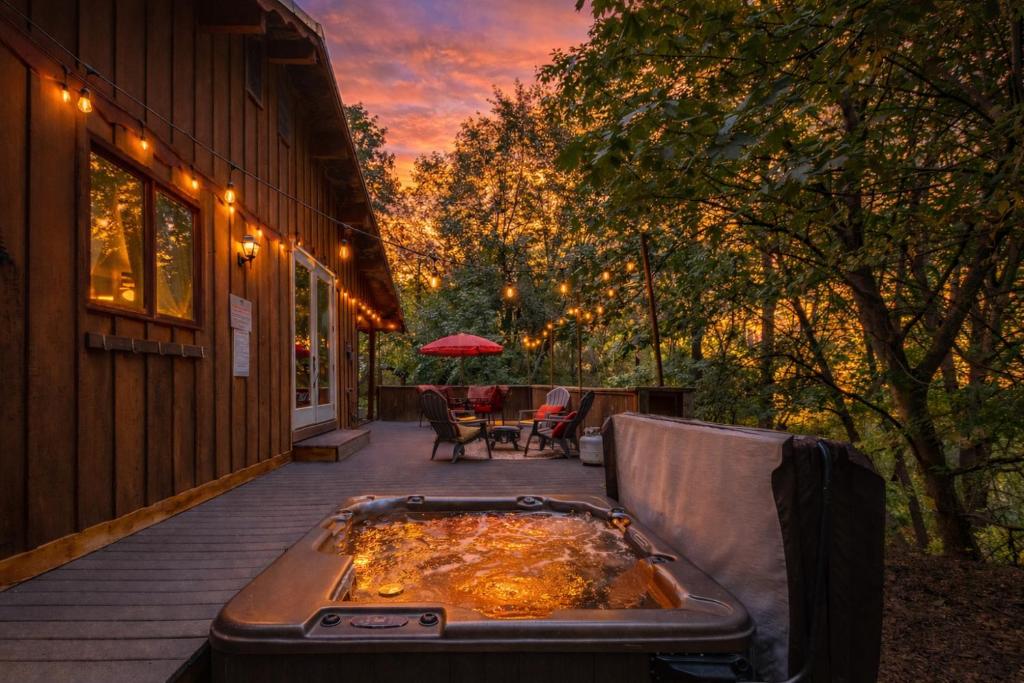 a hot tub on a porch with a table and chairs at Bear Paw Cabin in Leavenworth