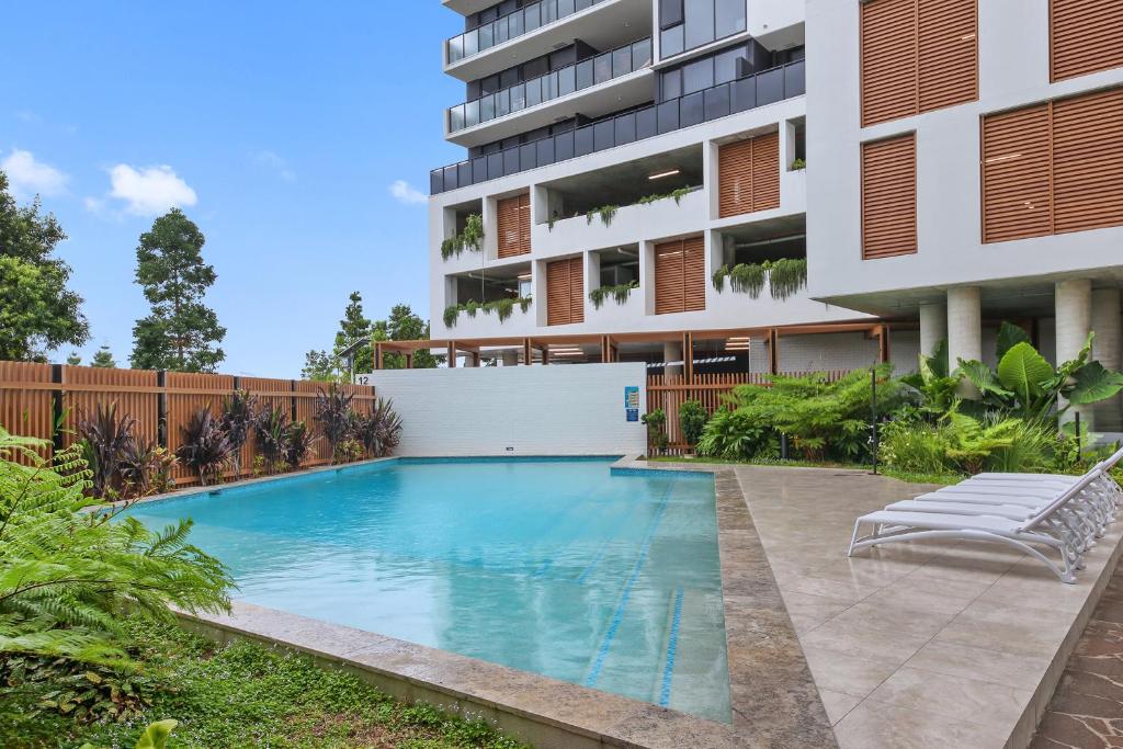 a swimming pool in front of a building at The Corso - Central Maroochydore Apartment in Maroochydore