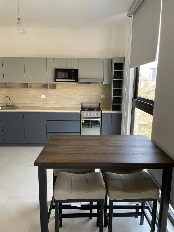 a kitchen with a wooden table and some chairs at Loftstay MYO in Monterrey