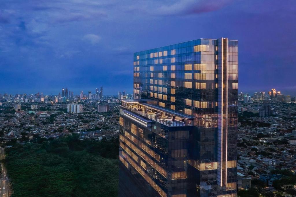 a tall building with a view of a city at Aloft by Marriott Jakarta Kebon Jeruk in Jakarta