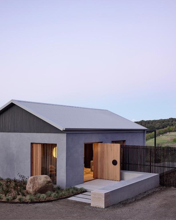 a house with a wooden door and a fence at Bassano Red Hill in Red Hill
