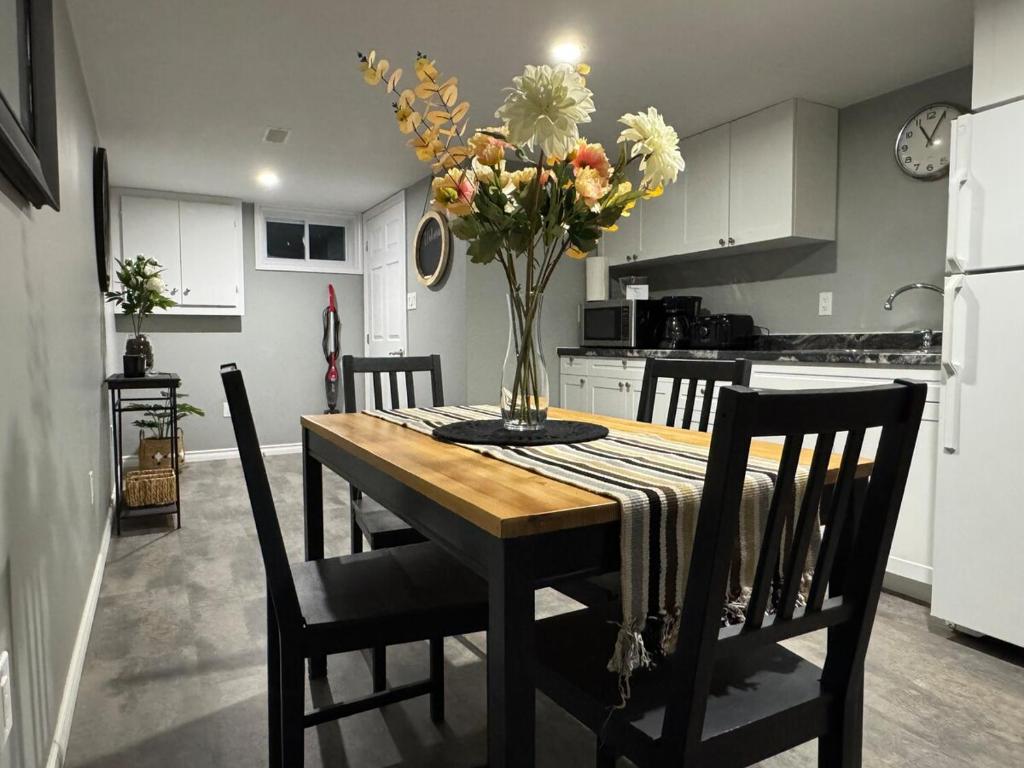 a kitchen with a table with a vase of flowers on it at Private Apartment for Business & Couples in Sudbury