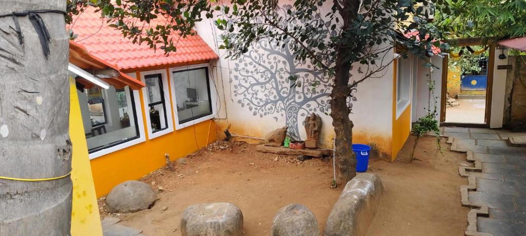 a house with a tree next to a building at Le Aham Boutique Hotel in Kuilapayam
