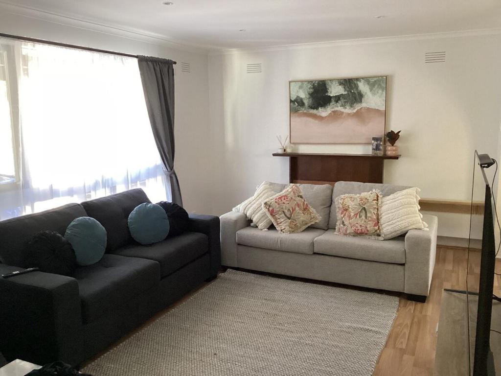 a living room with a black couch and a grey couch at Weekend Escape in Rosebud