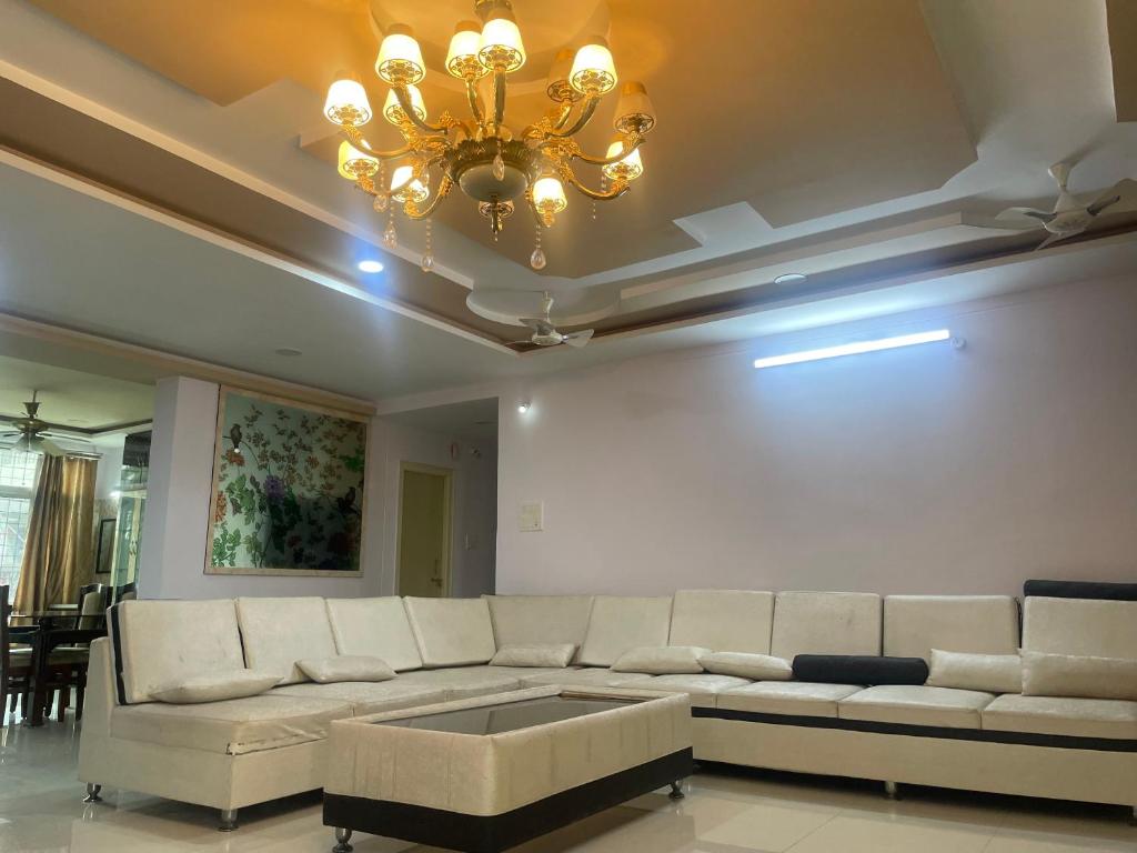 a living room with a couch and a chandelier at Elysium Inn in Hyderabad