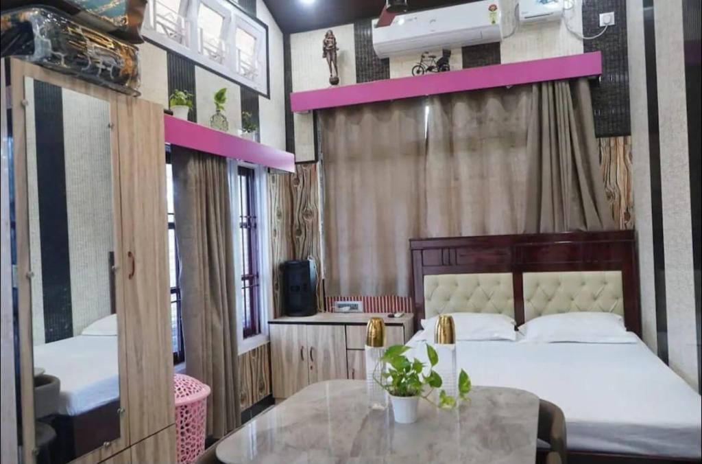 a room with two beds and a table in it at Sukoon Villa in Tezpur