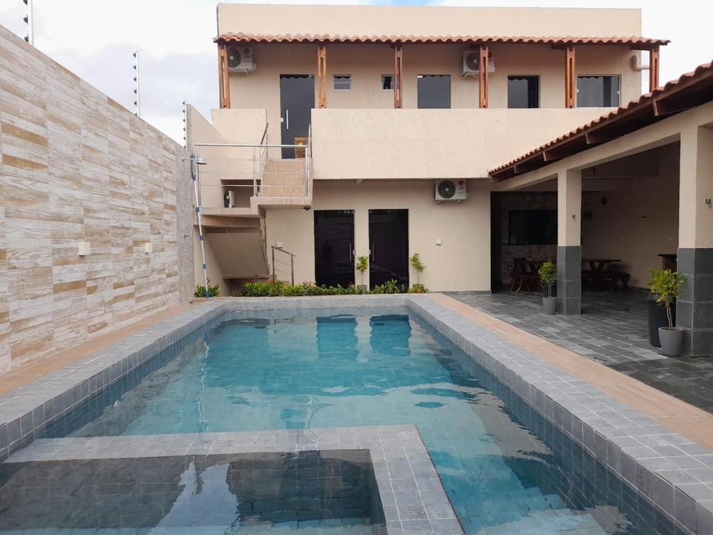 a swimming pool in front of a house at Pousada-Suítes Alto do Moura in Caruaru