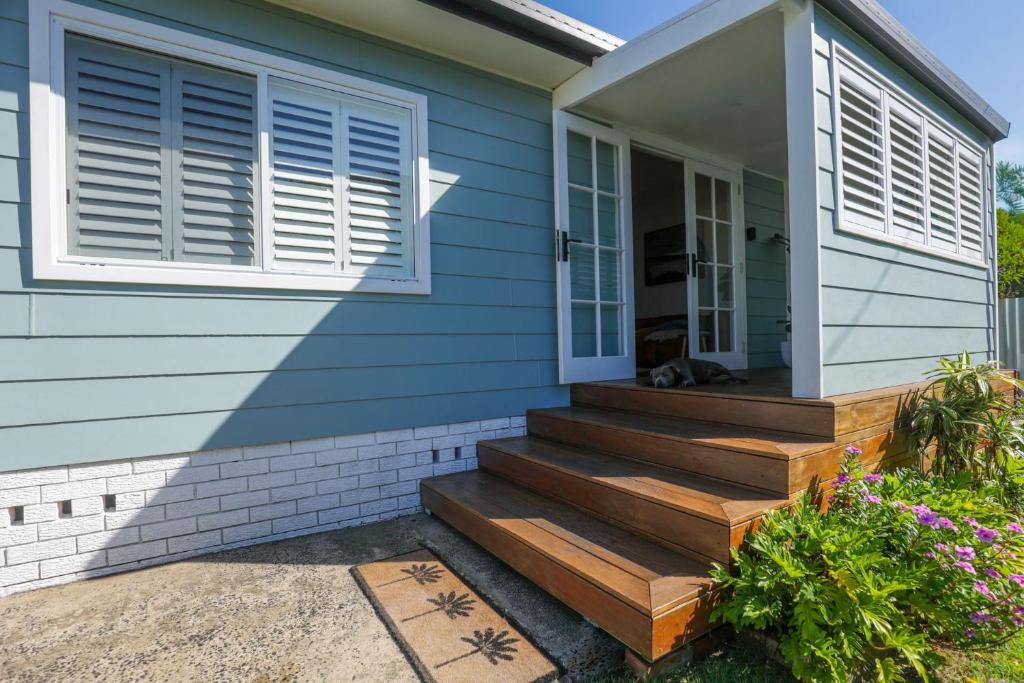 a house with a cat laying on the stairs at Bungalow Blue - 8 Illawong Lane in Evans Head