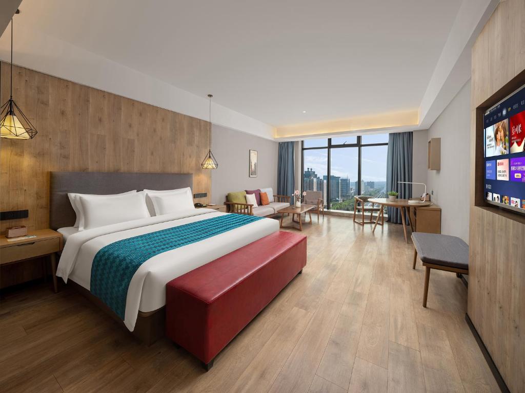 a hotel room with a large bed and a flat screen tv at 复美酒店 in Luoyang