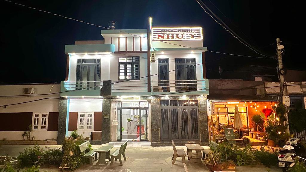 a building with tables and chairs in front of it at Nhà Nghỉ Như Ý in Phan Rang–Tháp Chàm