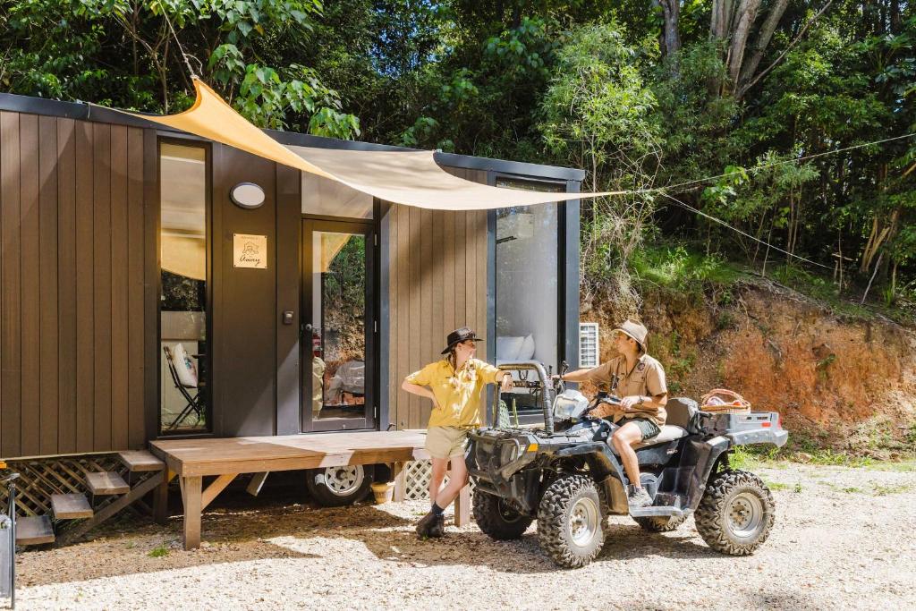 two men on a atv parked next to a tiny house at Raspberry Spring Corner by Tiny Away in Clothiers Creek