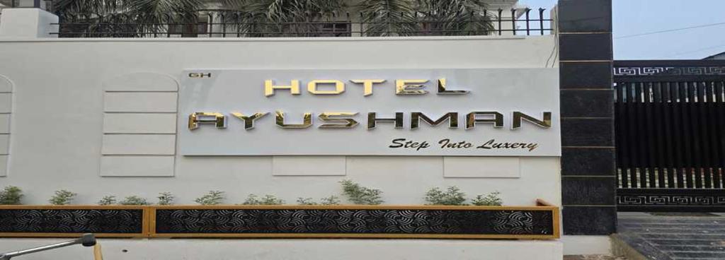 a hotel sign on the side of a building at HOTEL AYUSHMAN in Varanasi
