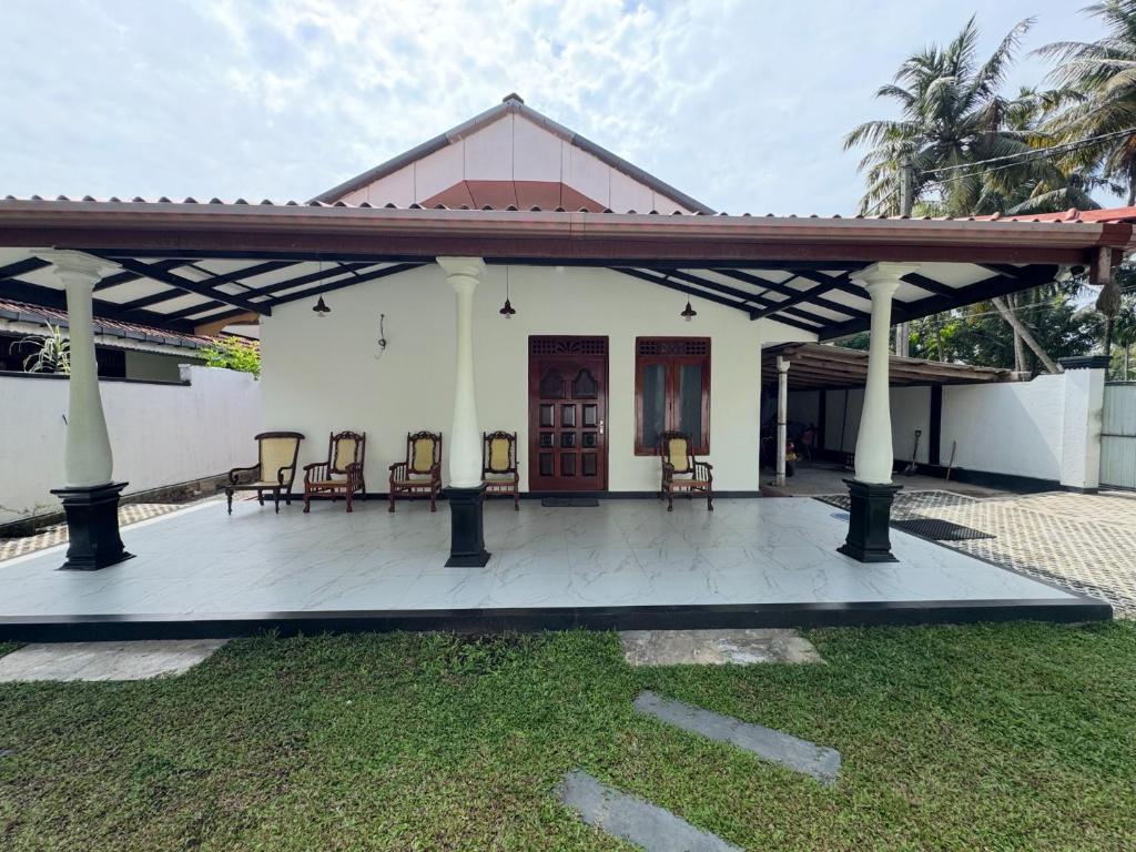 a house with a pavilion with chairs on a porch at Thousand Sunny Villa in Duwegoda