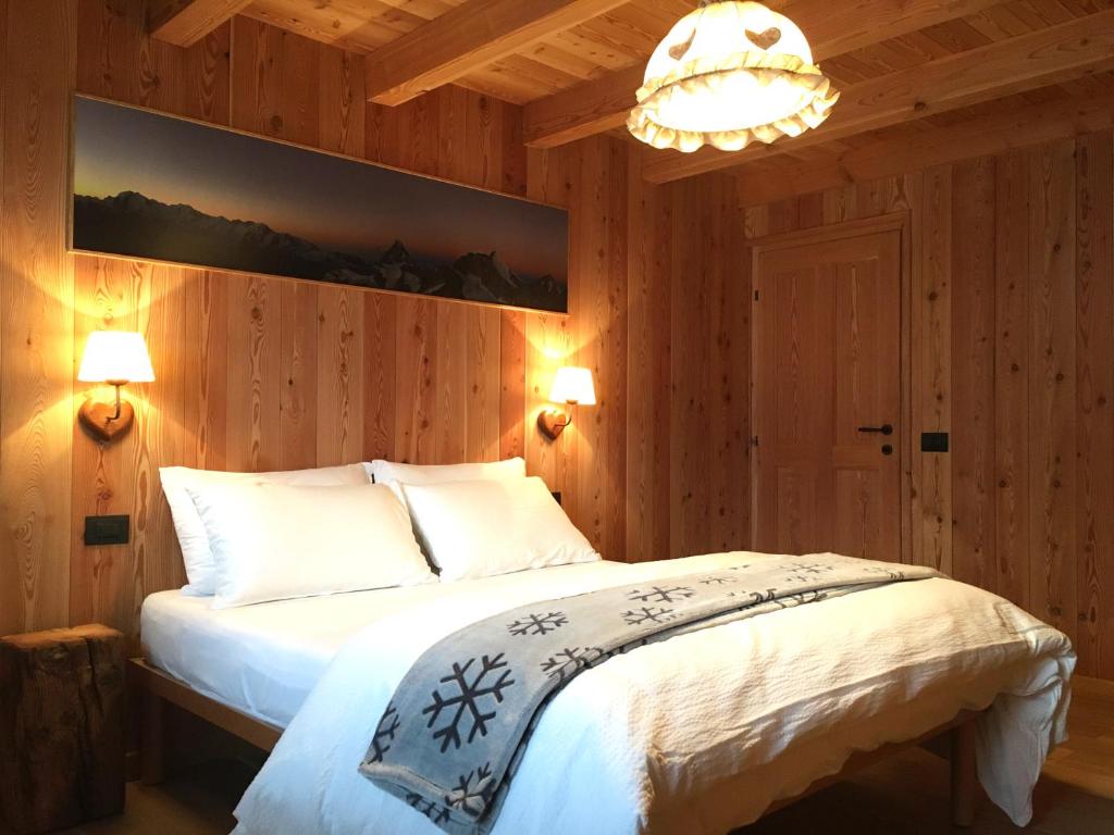 a bedroom with a bed and a chandelier at MaisonGorret in Valtournenche
