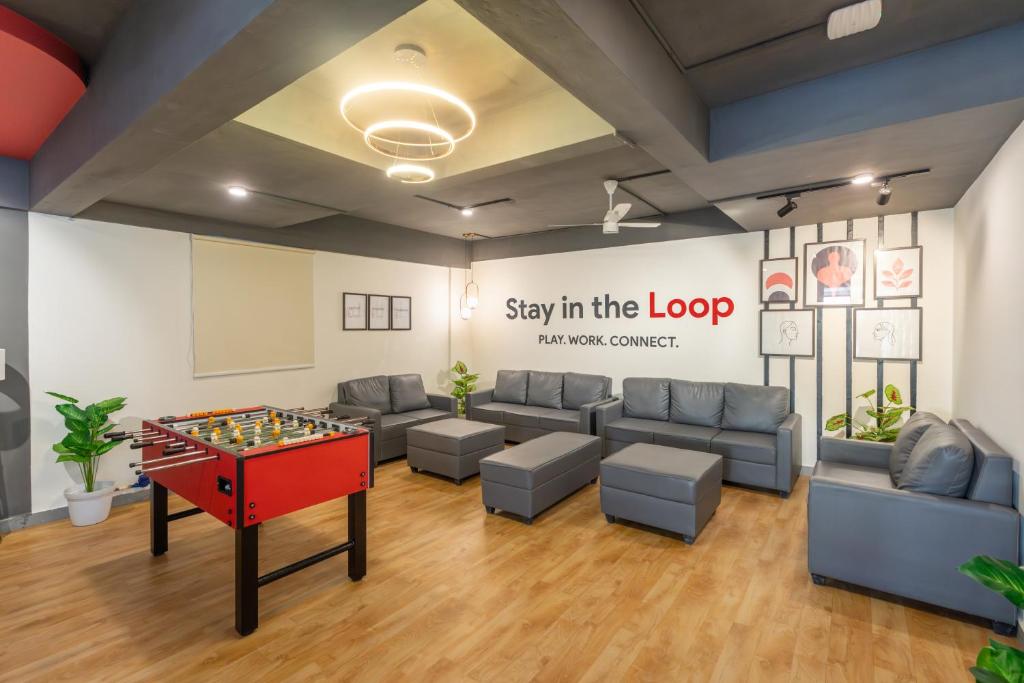 a room with a couch and a table with a chessboard at Loop by Zolo HSR Layout, Bangalore in Bangalore