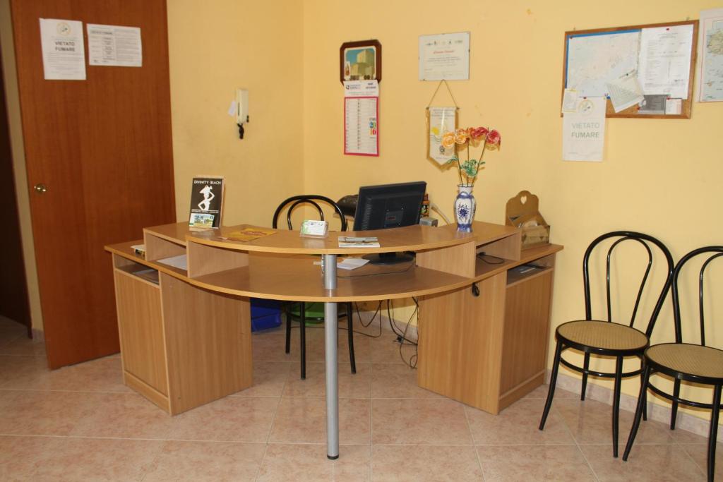 un ufficio con scrivania, sedie e computer di Garden House a Pozzallo