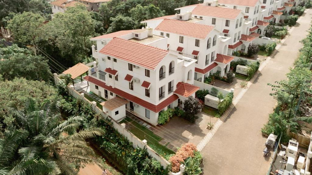 an overhead view of a large white house with red roofs at ELIVAAS Signature Casa Verdea 4-BHK Villa With Private Pool & Lift Near Popular Restaurants in Siolim
