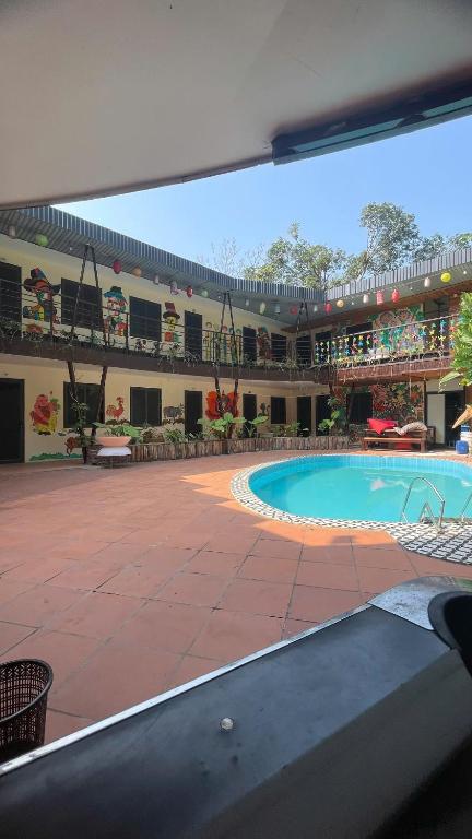 a large building with a swimming pool in a courtyard at Catba Chilling House Pool & Bar in Cat Ba