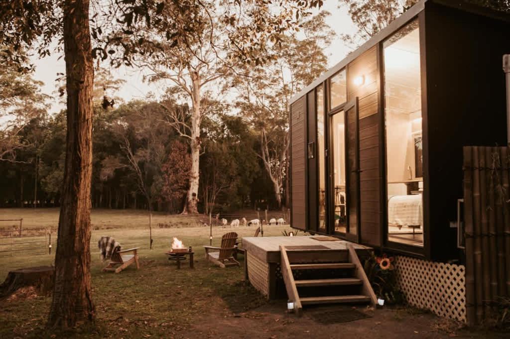 a house with a large window and a tree at The Stables by Tiny Away in Palmwoods