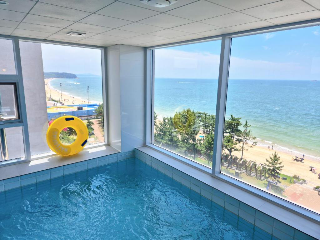 a swimming pool with a view of the ocean at 대천 아이오션 풀빌라 호텔 in Koryŏng