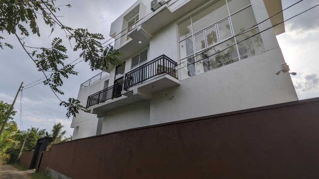 a white building with balconies on top of a fence at Breeze house in Tangalle