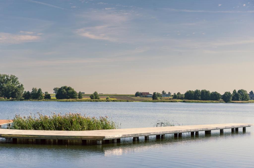 a dock in the middle of a lake at Błażejewko Resort in Błażejewko