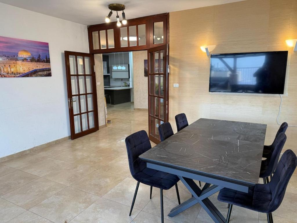 a dining room with a black table and chairs at Har nof rooftop in Jerusalem