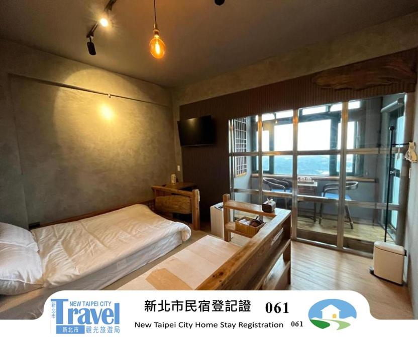 a bedroom with a bed and a view of the ocean at Hiding spot in Jiufen