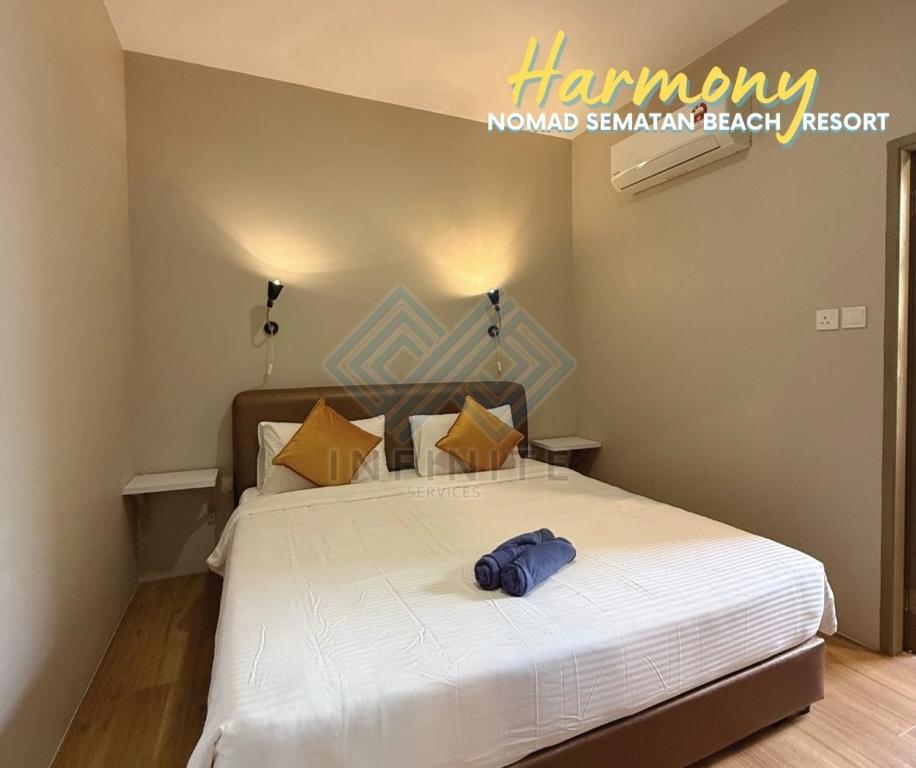 a bedroom with a bed with a blue hat on it at Harmony Serene 3BR Nomad Sematan Beach Resort in Sematan