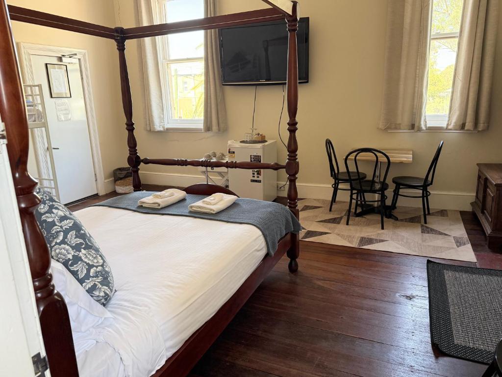 a bedroom with a canopy bed with a television on the wall at Imperial Homestead in York