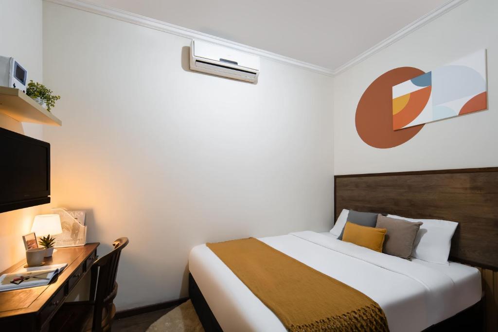 a bedroom with a bed and a desk and a tv at Cove Casavanda in Serpong